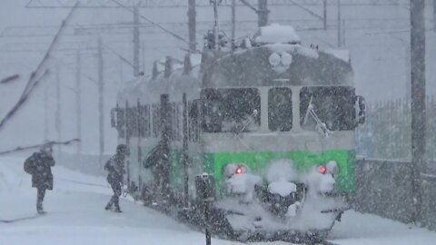 "Green train" passing by in heavy snow fall at Kymi, Finland 5.1.2022