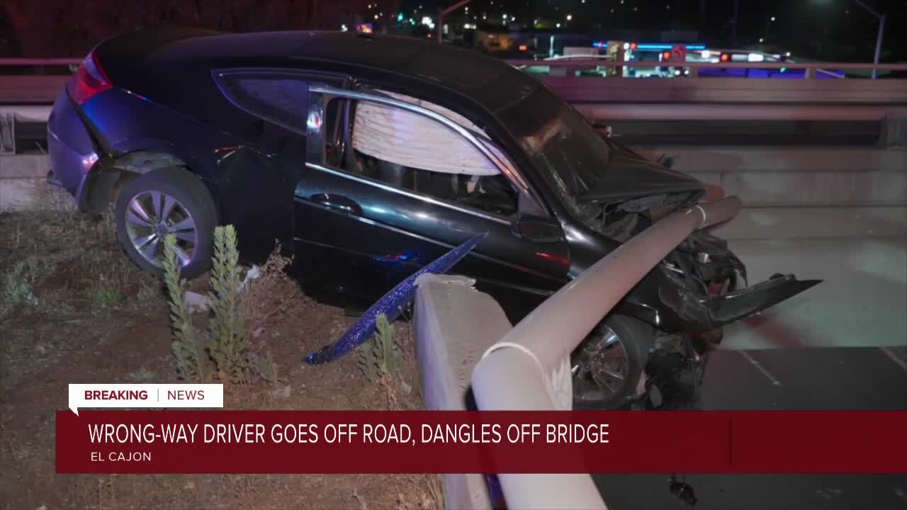 Wrong-way driver goes off road, dangles off bridge