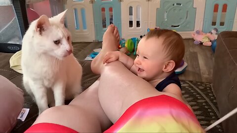 The child is playing very nicely with the cat