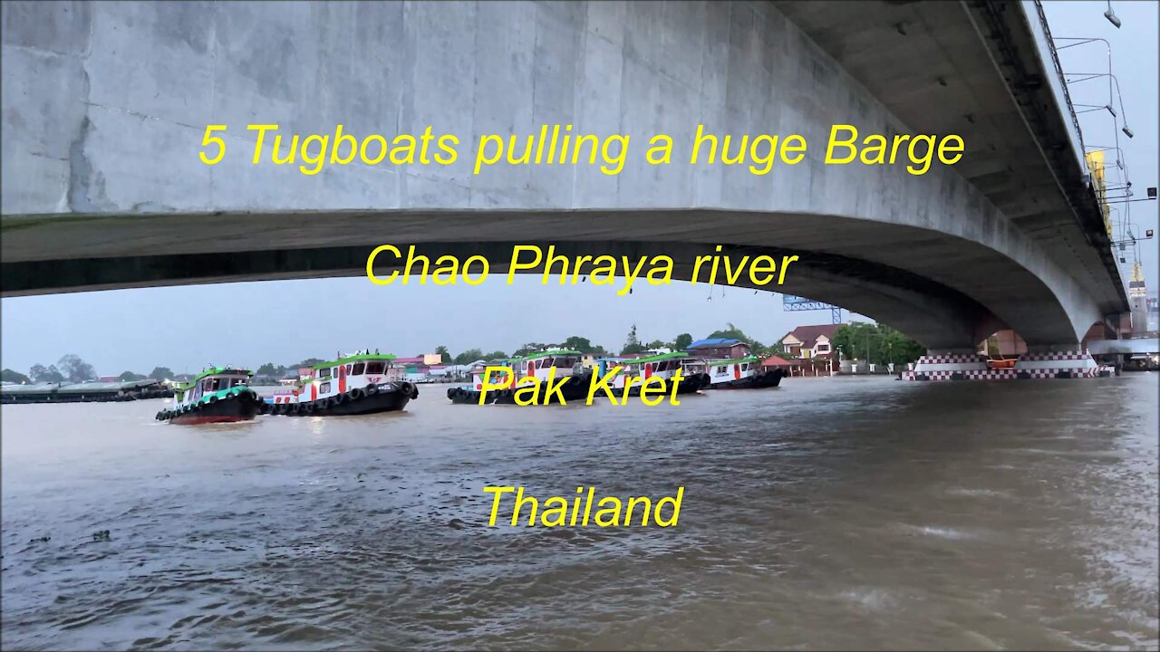 5 Tugboats pulling a huge barge at Pak Kret Chao Phraya river in Thailand