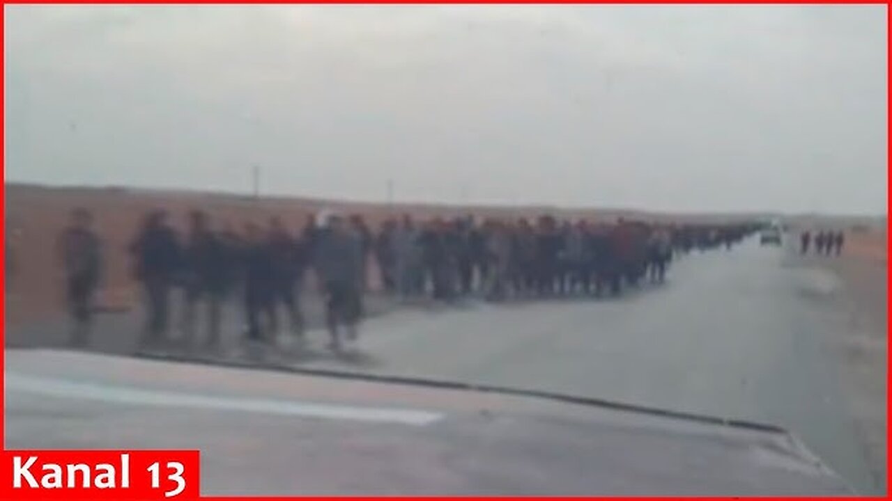 Image of thousands of Syrian soldiers leaving their weapons and marching towards Iraqi border