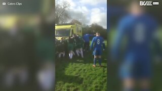 Squadre di calcio avversarie si uniscono per spingere l'ambulanza