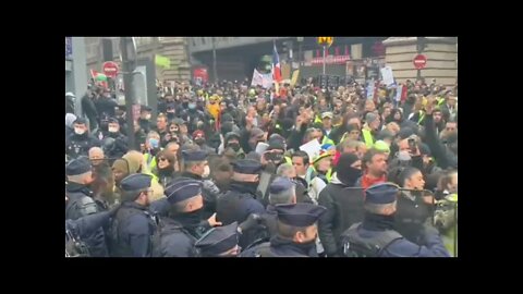 Police forced to move back by a tide of protesters against mandates in Paris.