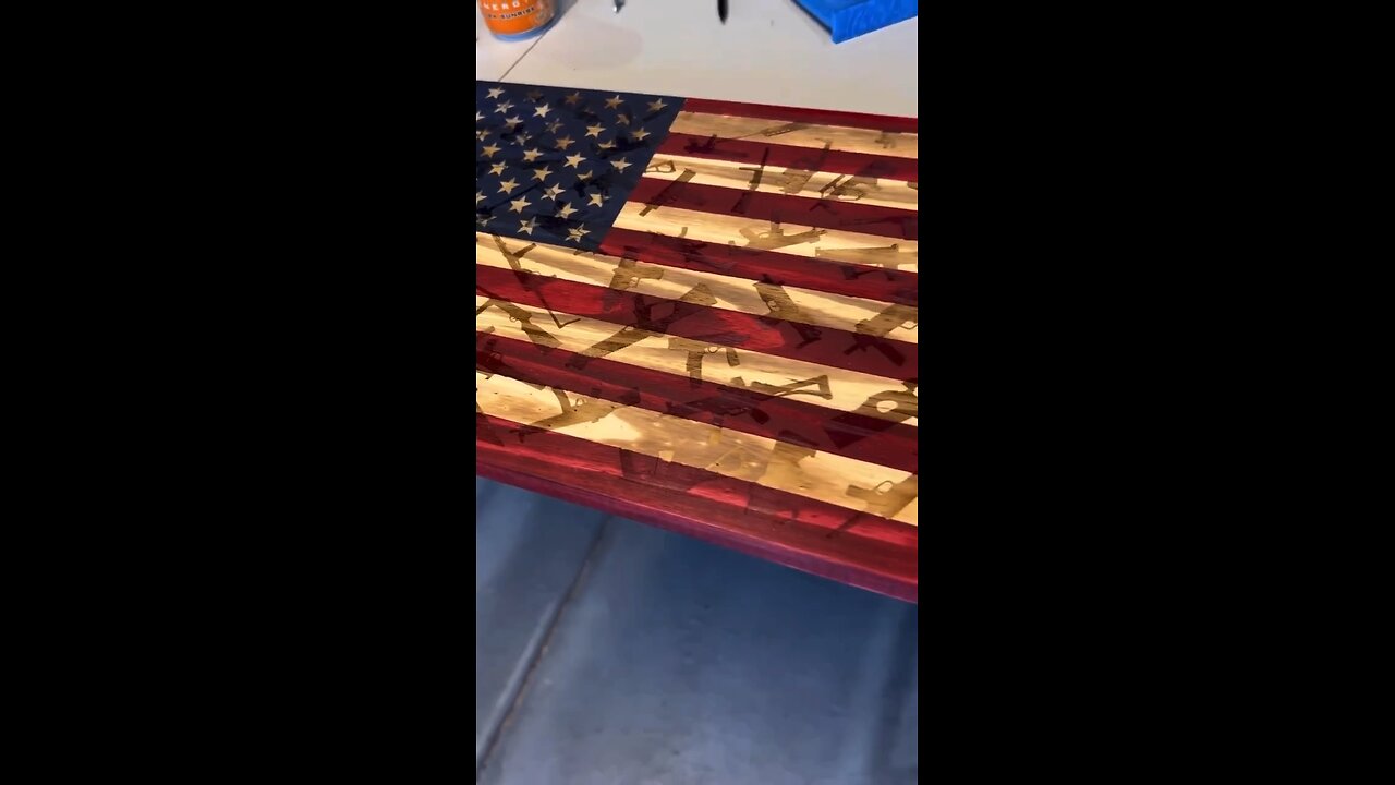 Wooden American flag with firearm background.