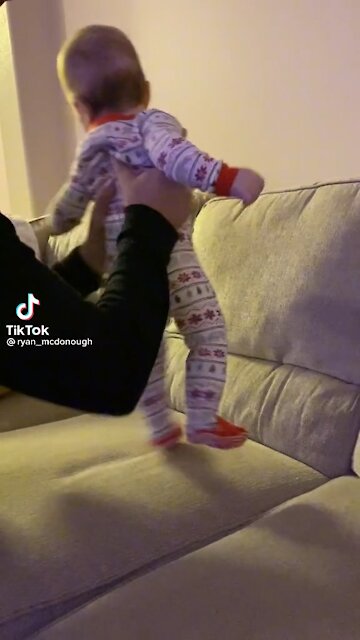 Baby laughs at role playing with family member