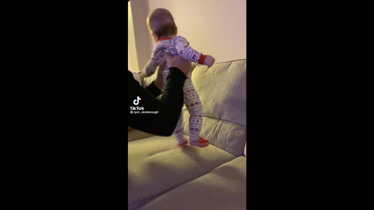 Baby laughs at role playing with family member
