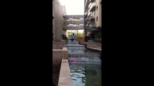 Young Man Walks Through A Fountain