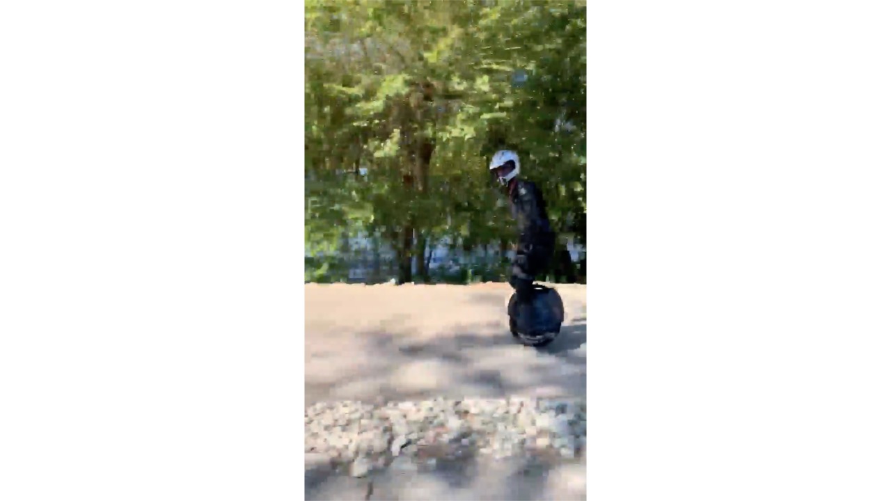 Unicyclist Races Past Car on the Lakeside Drive