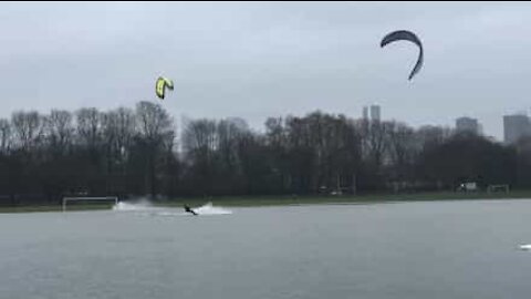 Kitesurfers si divertono in un campo da calcio inondato