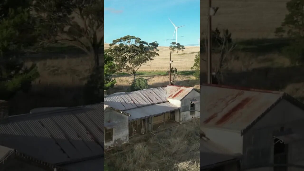 AUSTRALIAN OUTBACK WIND FARM SURROUNDS ABANDONED HOUSE.