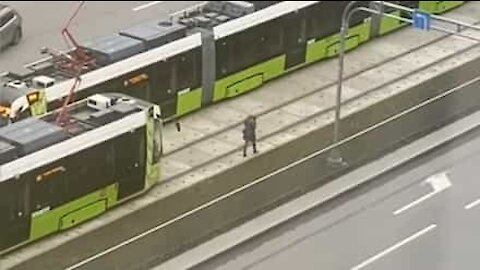 Woman with headphones in doesn't notice approaching tram