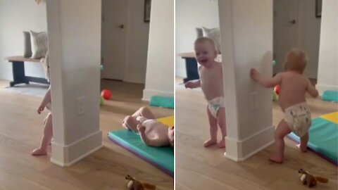 Twin babies playing hide and seek with adorable laughing