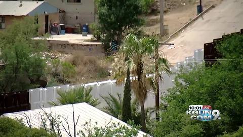 Section of Nogales border fence painted white