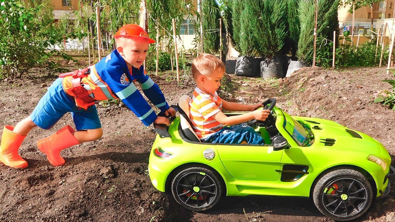 Nikita ride on children's car and stuck in the ground Vlad tows on the tractor