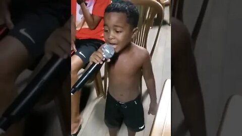 Menininho da um show no microfone cantando QUEDA de Glória Groove