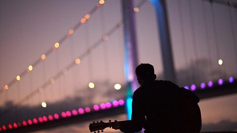 Man playing guittar in the dark with cool colour code