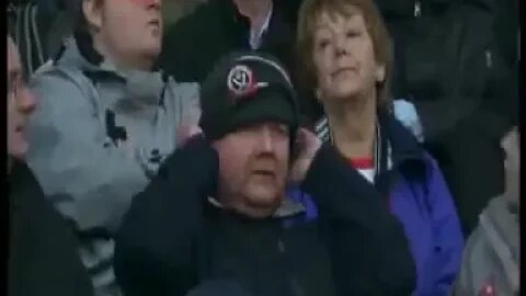 Fan Pulls Hat Over Mans Head At Football Match