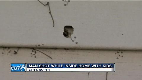 Stray bullet hits man feeding baby in home during shootout