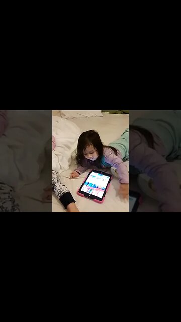 Baby Cassie and her sister are watching a show on Ipad