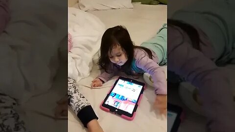 Baby Cassie and her sister are watching a show on Ipad