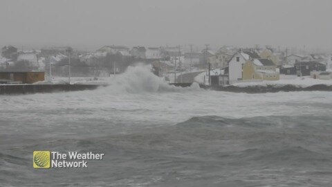 Waves crashing against the sea wall on a chilly afternoon