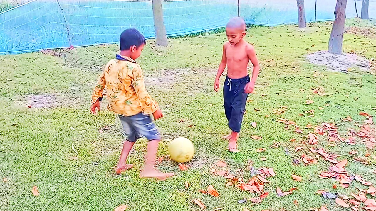 Little kids playing football in the field