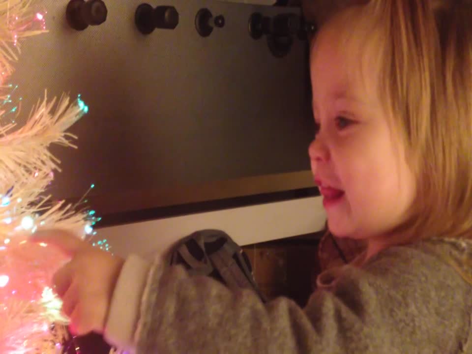 Little Girl is Amazed by her Glowing Christmas Tree