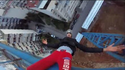 Jovem sobe guindaste e pendura-se invertido!