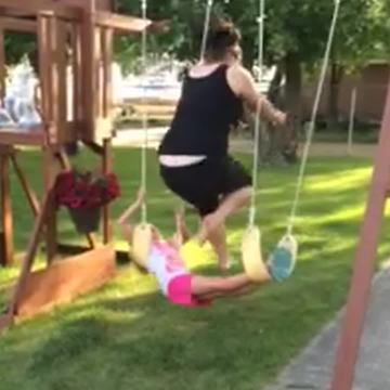 "A Girl Lays Across Two Swings And Teen Girl Jumps Over Her"