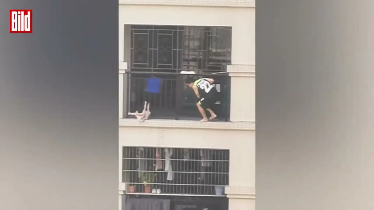 Kind zwängt sich durch Metallstäbe und hängt vom Balkon runter China