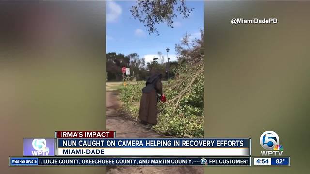 Nun with chainsaw cuts downed tree from Hurricane Irma