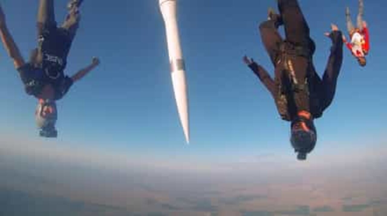 Skydivers jump with a missile