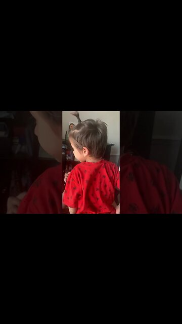 Sweet baby boy is kissing mommy on lips while she is doing make up