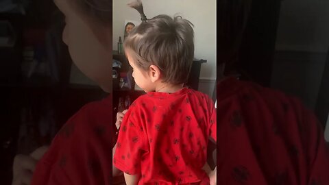 Sweet baby boy is kissing mommy on lips while she is doing make up