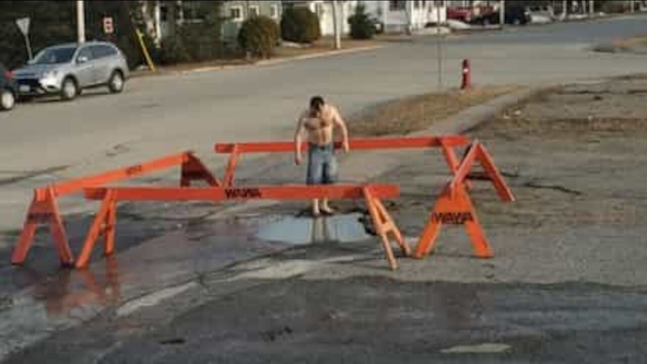 Un jeune teste une petite piscine en pleine rue