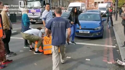 Angry Blue Collar Father removes protestors from street to pick up his child in UK