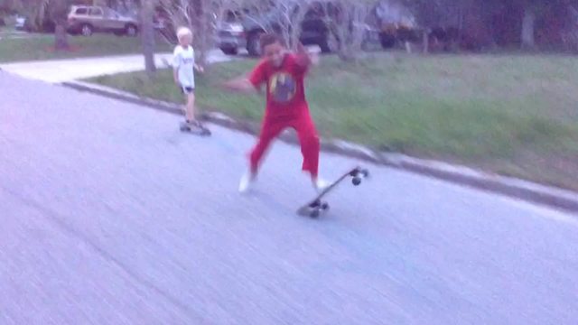 Young Boy Falls Off His Skateboard While Taking Over His Friend