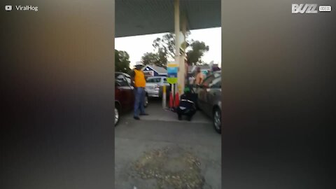 Berusad kvinna improviserar en dansuppvisning på bensinmack