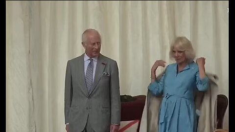 Amusing moment Queen Camilla throws coat off her shoulders