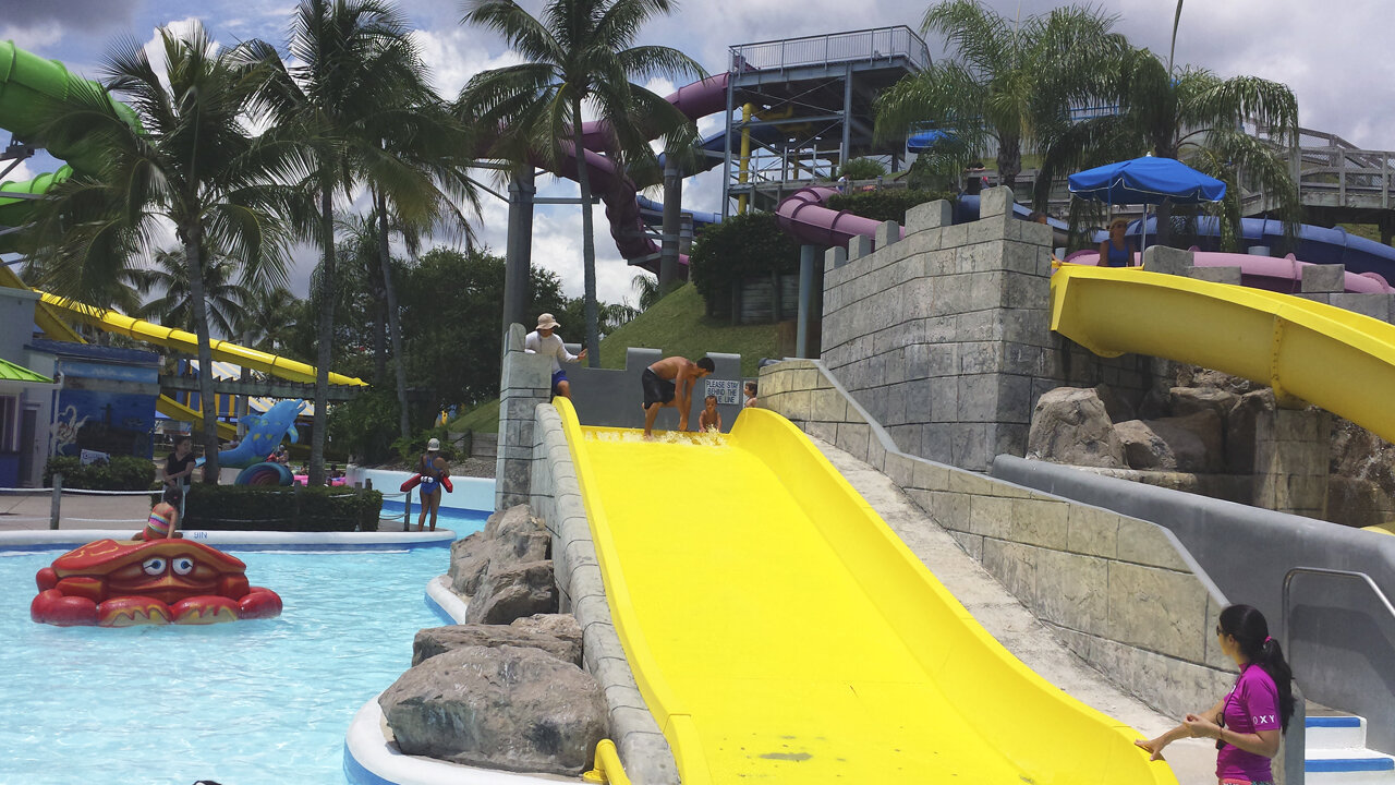 Mi hijo y mi nieto se deslizan por el canal de agua. Parque de agua en West Palm Beach