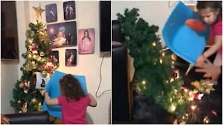 Une fillette fait tomber le sapin pour atteindre l'étoile