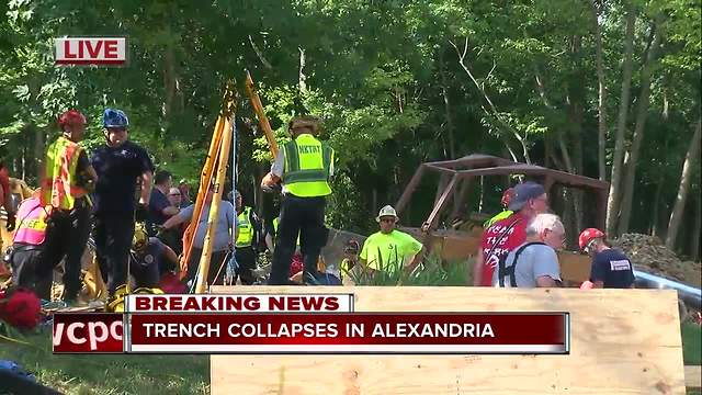 Officials work to save man from collapsed trench