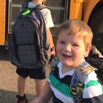 A Little Boy Trips And Falls Off A School Bus