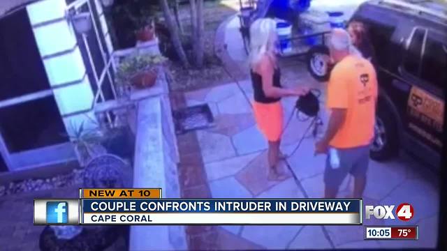 Surveillance video shows couple confronting intruder breaking into their car