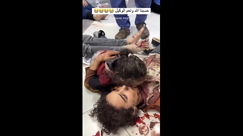 Injured mother in Gaza tries to comfort her daughter on a hospital floor
