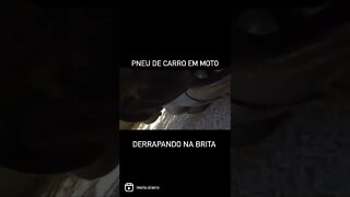 Pneu de carro em moto, derrapando na Brita