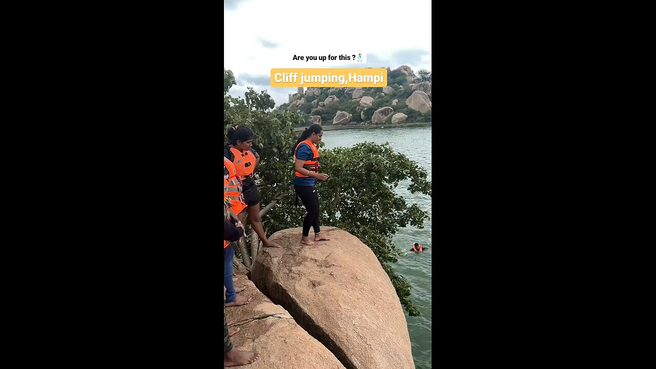 People having fun in water jumping off cliff