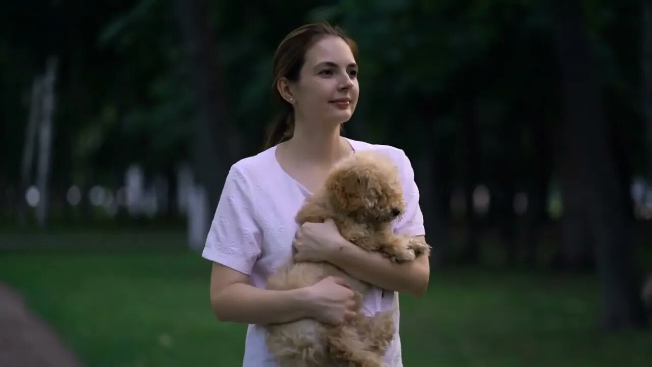 Woman with toy poodle walking in a park 2