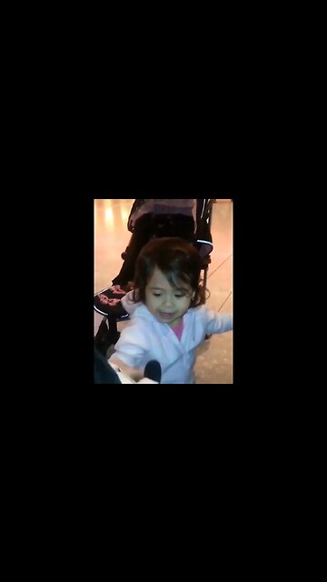 Cute baby girl dancing in the airport with her Minnie Mouse doll