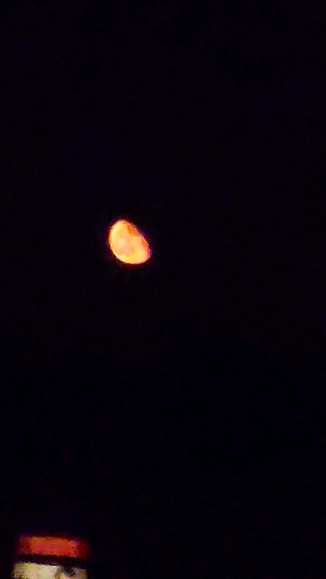 Huge Moon, that's the color of a construction Barrel